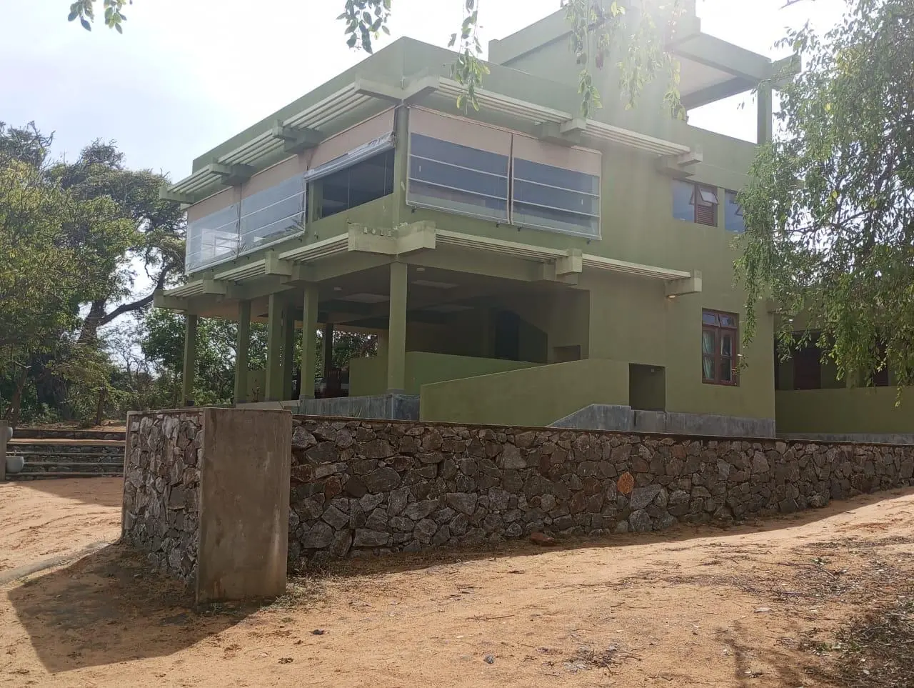 Daytime exterior of Yala Parana Thotupola Resort surrounded by dry-zone trees